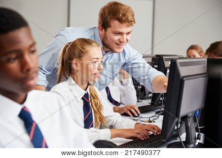 Teenage Students Wearing Uniform Studying In IT Class