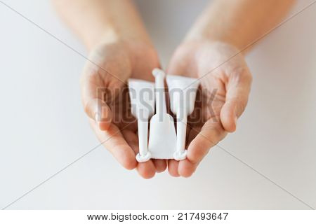 medicine, healthcare and pharmaceutics concept - hands holding tubes of micro enema