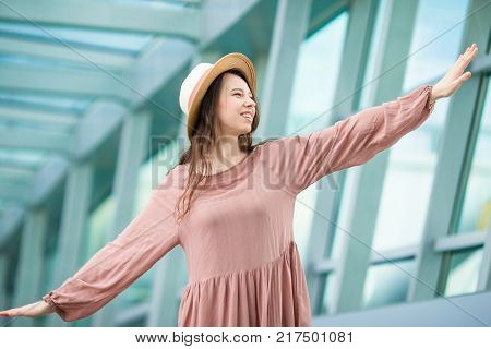 Young woman in international airport walking with her luggage.