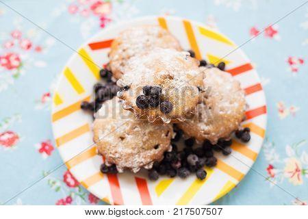 Blueberry muffins on plate and bright floral cloth