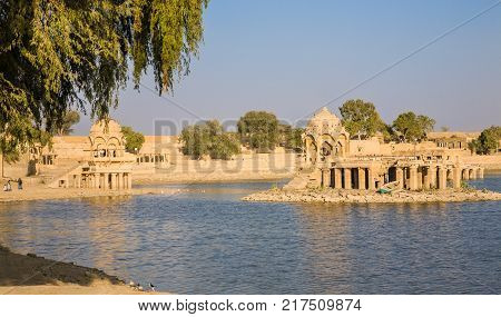 Jaisalmer India - 2015 January 5 : The artificial Gadsisar Lake with temples and ghats near the desert town of Jaisalmer in the Rajasthan region of northern India