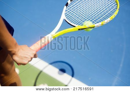 Closeup of a player holding the racquet and preparing for the serv at the baseline