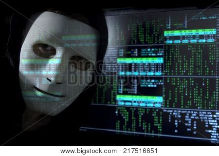 A man in a mask on the background of binary code.