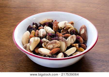 Bowl of nuts and dried fruits shot from a low angle, containing almonds, pistachios, brazil nuts, pecans, cranberries and dried cherries. Food rich in proteins, antioxidants and essential nutrients act as a healthy snack.