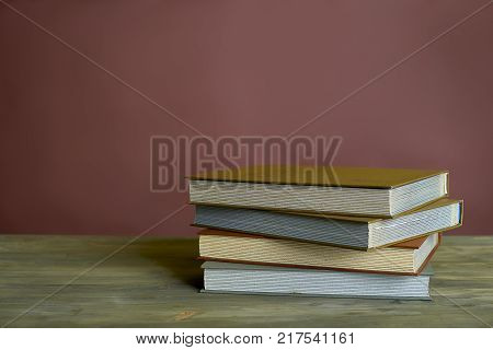 Four stamp albums books bunch on wooden table and bordeaux background