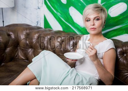 Beautiful Woman Sitting On Leather Sofa