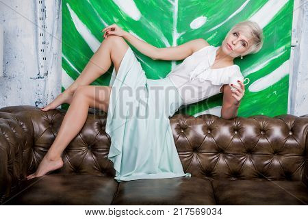 Beautiful Woman Sitting On Leather Sofa
