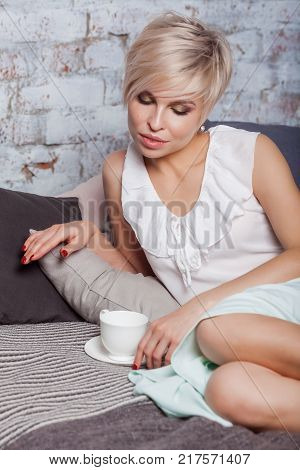 Beautiful Woman Sitting On Leather Sofa