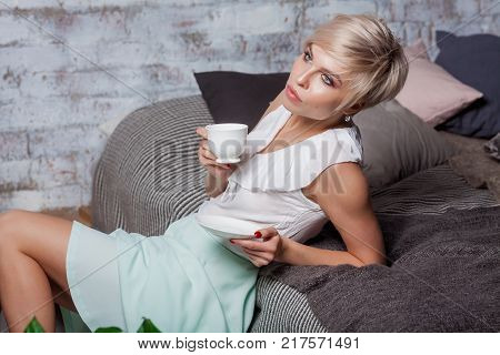 Beautiful Woman Sitting On Leather Sofa