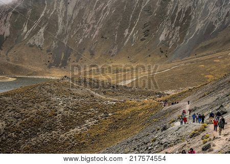 People walking Volcano Nevada de Toluca with lakes inside crater in Mexico