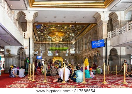 NEW DELHI INDIA - MARCH 18 2016: Horizontal picture of indian people of Sikh religion praying inside Gurudwara Sisganj Sahib located in New Delhi India.