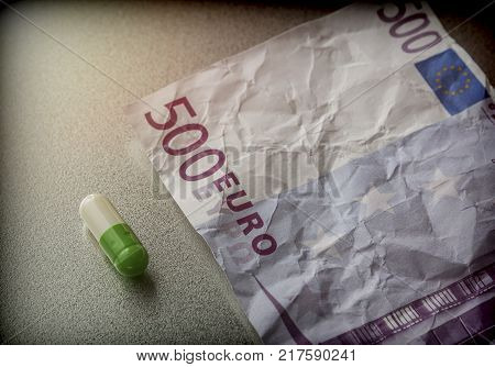 Capsule of white and green on a ticket used 500 euros, conceptual image