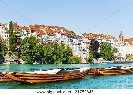 Lovely view of the Rhine embankment in Basel with wooden boats in the foreground at sunny day