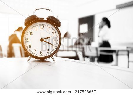 Alam clock located on wood teacher table in final exam room of secondary school college university classroom students in Asia Thailand. It show a timeout sign. in secondary school Education concept