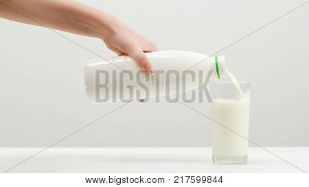 Woman pours milk. Dairy products. Calcium , vitamin D and amino acids concept. Fitness lifestyle.