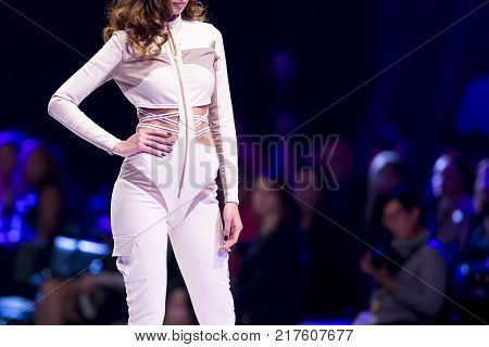Sofia, Bulgaria - 28 September 2017: Female model walks the runway in white dress during a Fashion Show. Fashion catwalk event showing new collection of clothes. White dress.