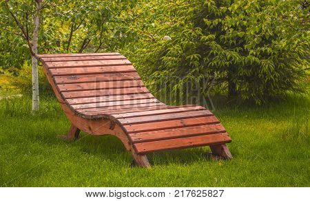 wooden bench on a lawn with green grass.