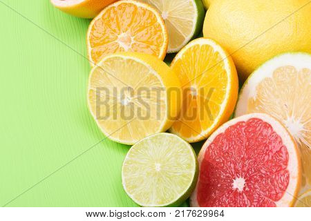 fruits with vitamin C are finely chopped and the green background Apelsin and lemons