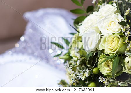 Beautiful wedding bunch with different flowers selective focus and blurred wedding dress background