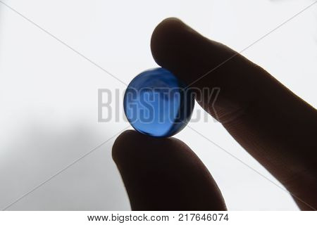 Look to inverted world through the blue glass ball in fingers.