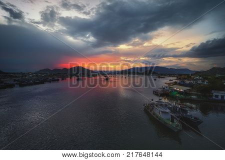 A fiery sunrise sky looking out sea in Muine Vietnam. With fishing boats in silhouette.