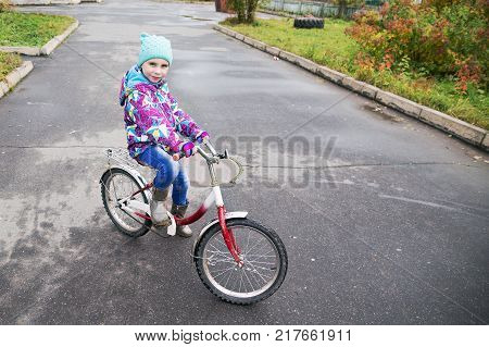 Child on a bicycle on an asphalt track.