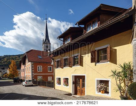 Beautiful paved street with old residential houses and gothic parish church. Gmuend in Kaernten, district of Spittal an der Drau, federal state of Carinthia, Austria