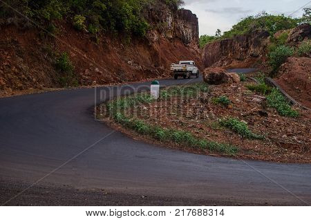 A road with curves going uphill and vehicle