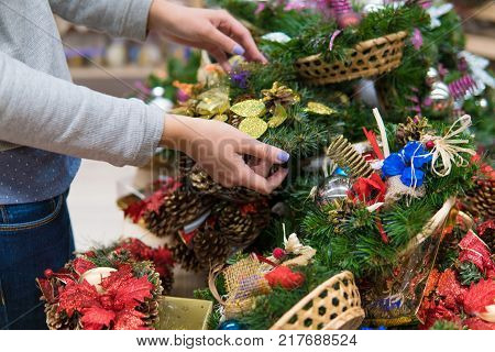 Closeup view of customer choosing Christmas decorations. Various choice of New Year's wreath with decorations