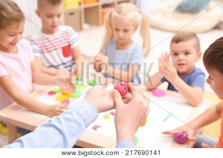 Little children engaged in playdough modeling at daycare