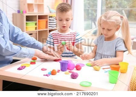 Little children engaged in playdough modeling at daycare