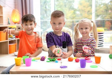 Little children engaged in playdough modeling at daycare