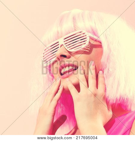 Beautiful woman in a bright pink wig on a pink background