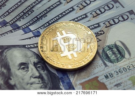Golden bitcoin with Benjamin Franklin portrait from one hundred american dollars. Business concept of worldwide cryptocurrency. Buying bitcoins for dollars. Earnings on the growth of bitcoin.