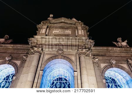 Madrid, Spain - December 8, 2017: Puerta of Alcala in Madrid at night on Christmas time. Low angle view