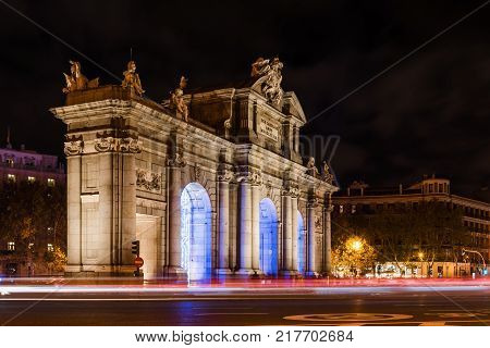 Madrid, Spain - December 8, 2017: Puerta de Alcala in Madrid at night on Christmas time with light trails of traffic