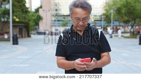 Senior man using mobile phone at outdoo