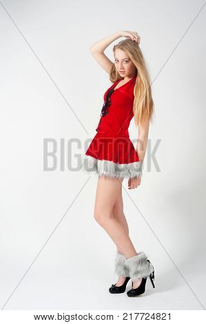 Beautiful sexy blonde female model dressed in a Santa Claus hat and dress. Sensual girl for Christmas
