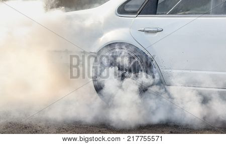 race car burns rubber off its tires in preparation for the race