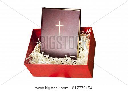Red bibile in the gift box with paper filling on white background. Christian isolated composition