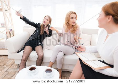 A teenage girl with her mother at a psychologist's reception. The girl has a complicated character. She does not listen to adults. She loves rock music and dressed in a leather jacket.