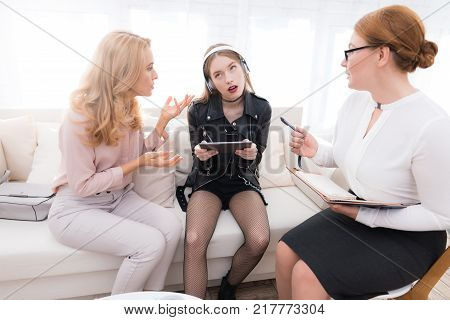 A teenage girl with her mother at a psychologist's reception. The girl has a complicated character. She does not listen to adults. She loves rock music and dressed in a leather jacket.