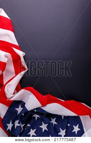 The American flag the symbol of independence lies unevenly along the perimeter of the lower and the left side on a gray background