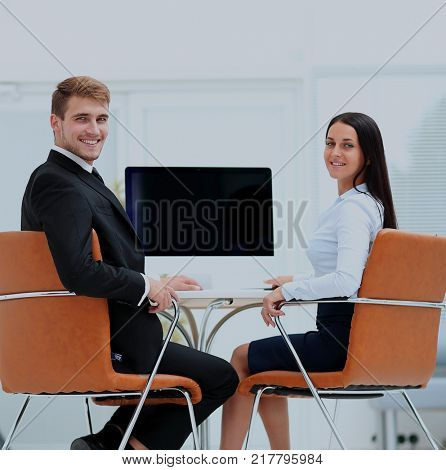 Happy business people looking at camera in office and  using com