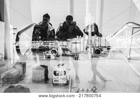 Friends in the airport waitig for departure, reflection in window