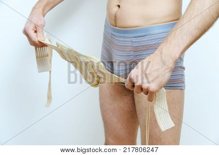Prevention inguinal hernia. A man is girding with a hernia belt.