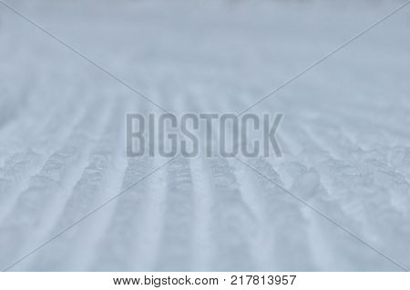 Close-up stripes of snow texture after snow groomer