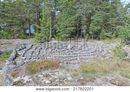 Maze or labyrinth made of gray stones in the pine forest