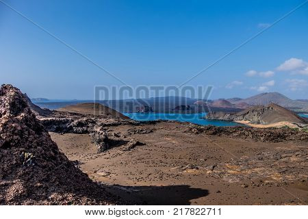 Beautiful barren Galapagos landscape view of Bartolome Island with unusual volcnic rock formations and blue sky