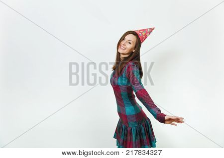 Beautiful caucasian fun young happy woman in plaid dress and birthday party hat with shy charming smile and brown hair celebrating and enjoying holiday on white background isolated for advertisement